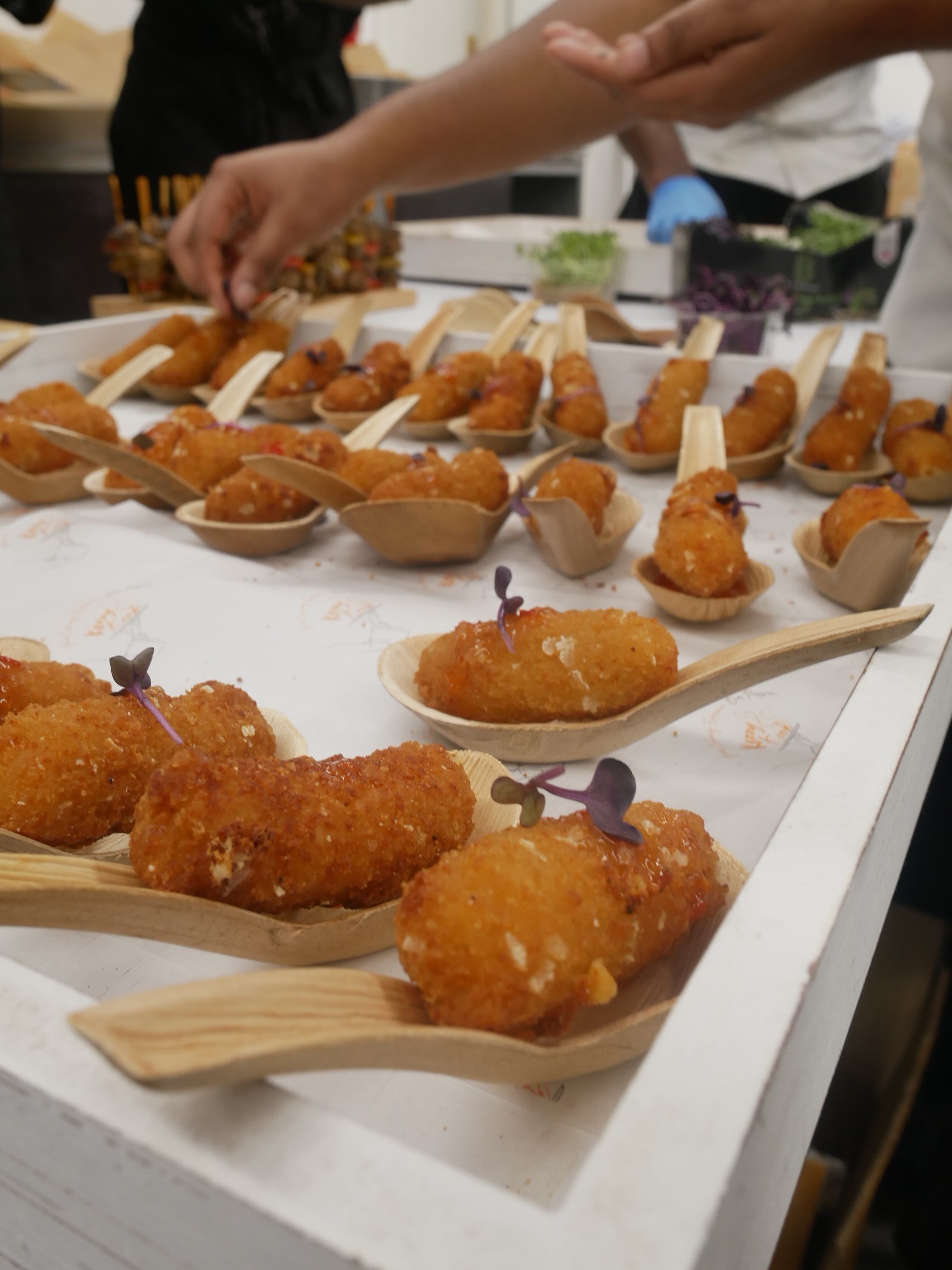 KezzyKooks canapés being finished with fresh microgreens at an event