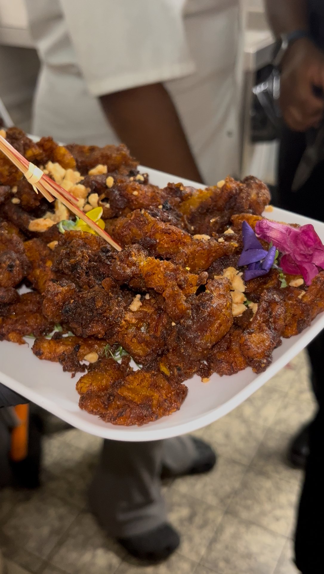 Platter of KezzyKooks glazed chicken wings garnished with edible flowers