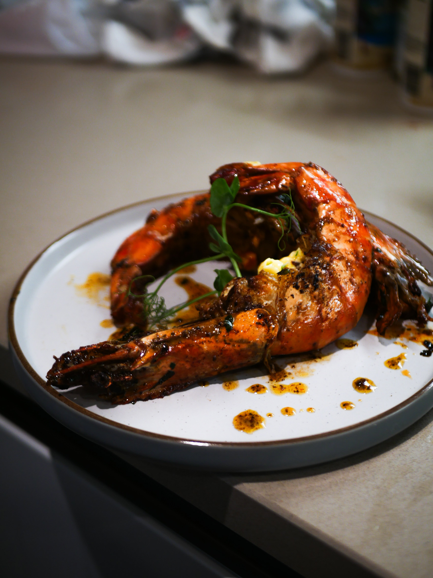 Spiced grilled prawns plated with pea shoots and sauce — a signature KezzyKooks fine-dining course