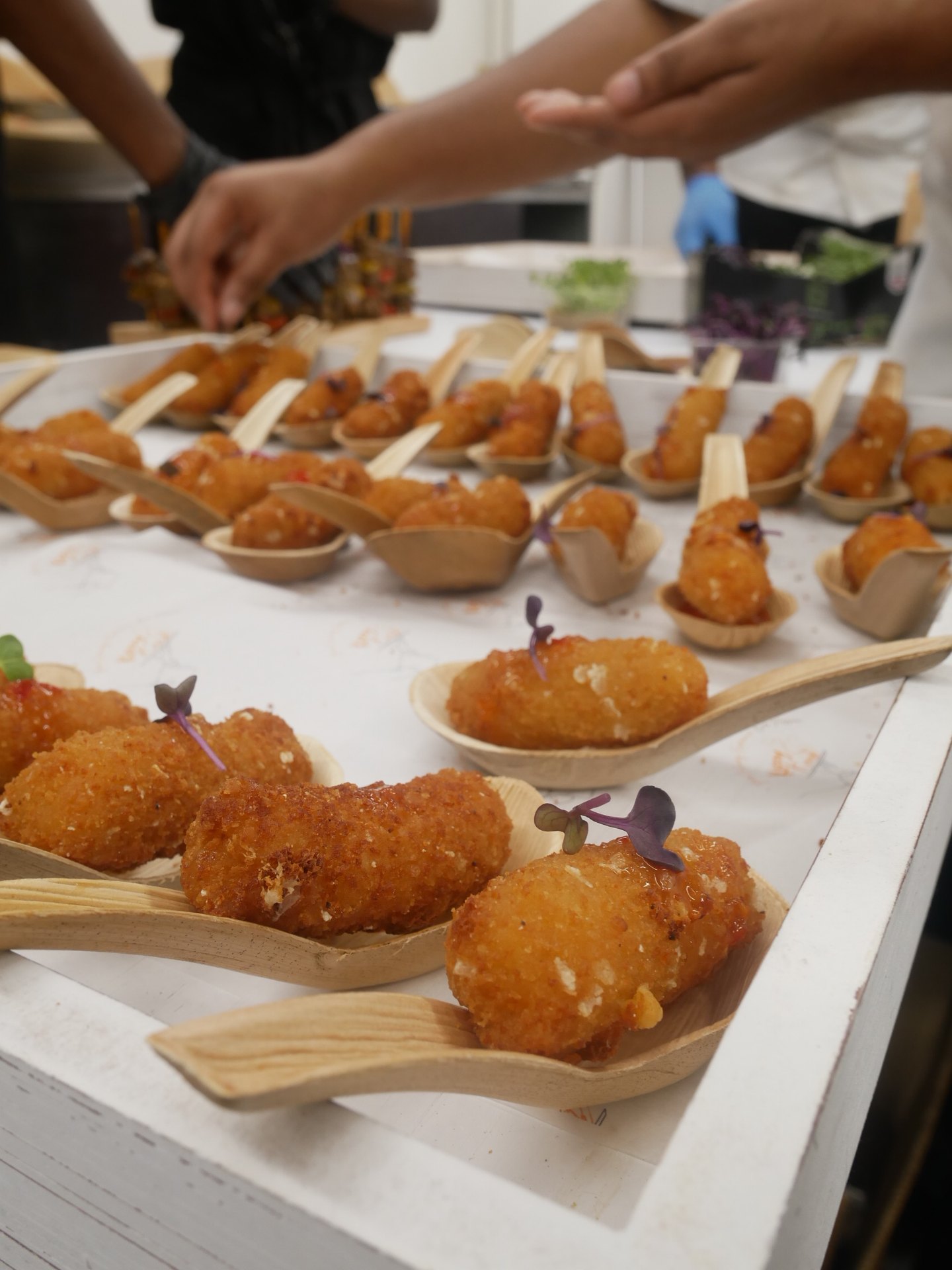 Wedding canapé tray of crisp bites on wooden spoons