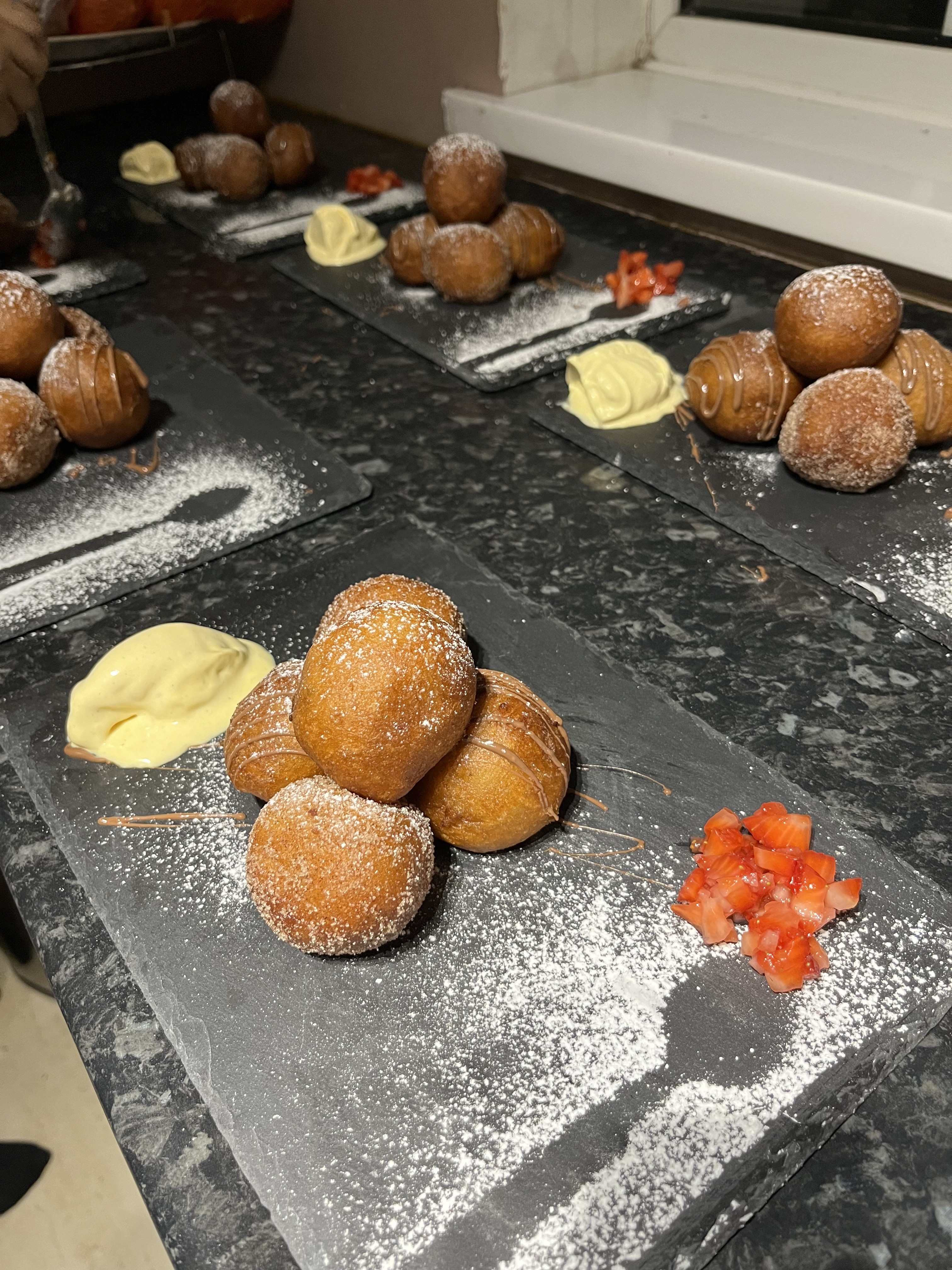 KezzyKooks plated puff-puff dessert served on dark slate
