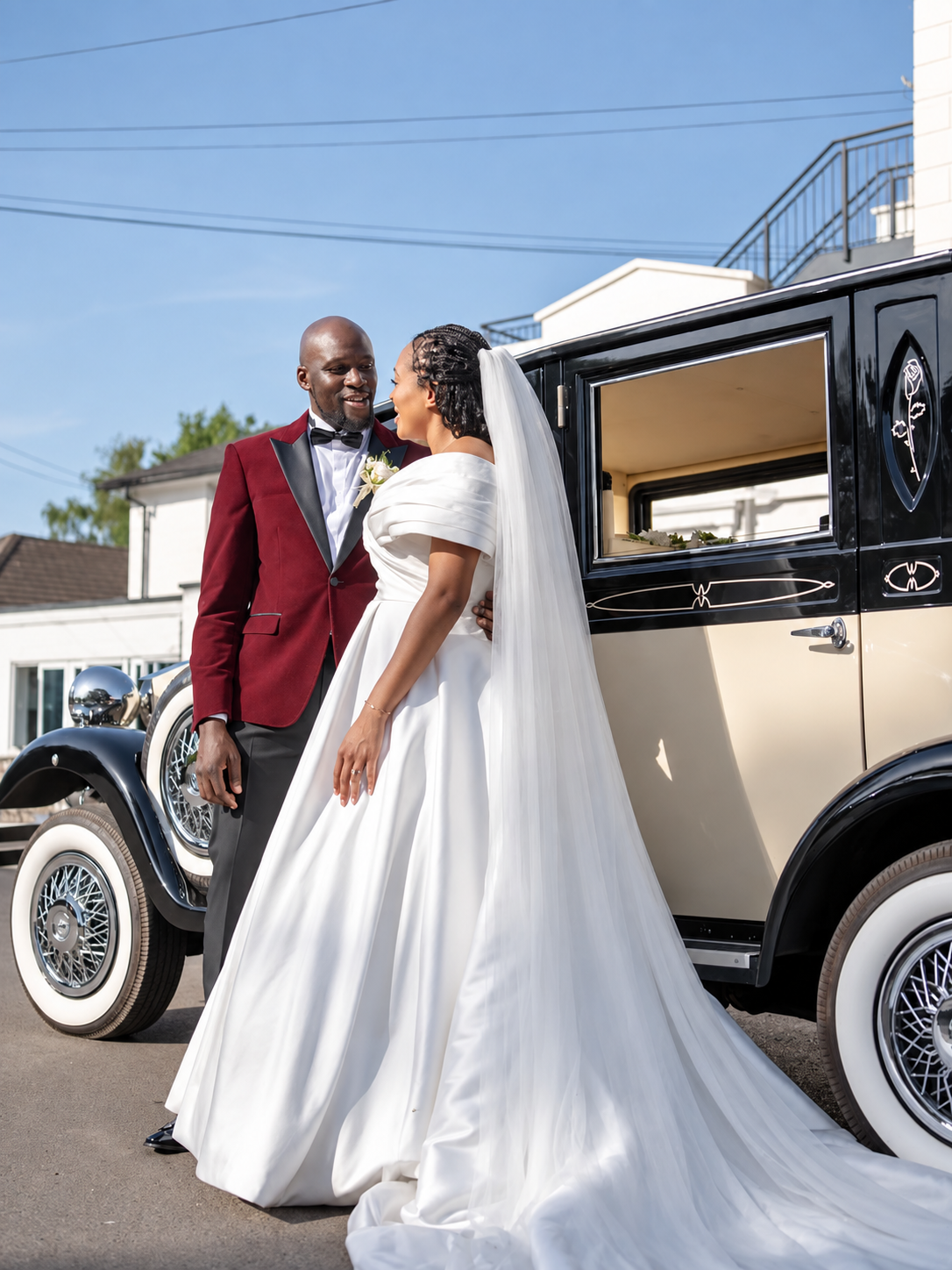 Newlyweds beside a vintage wedding car before their reception