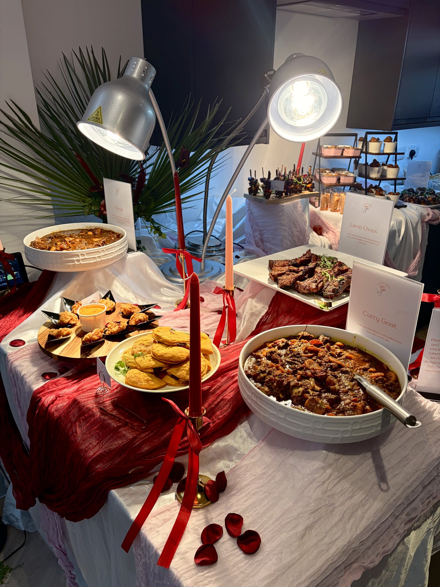 KezzyKooks celebration table dressed in red and white with patties, jollof and canapés